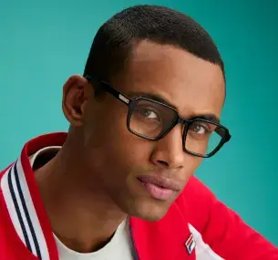 A 35-year-old mulatto man with short black hair wears a red and white sweatshirt and black acetate eyeglasses with a metal detail on the temple that has the FILA logo engraved with the letter F.