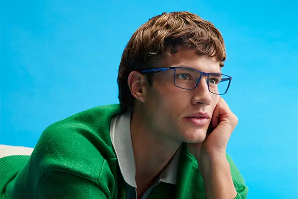 Blonde man wearing eyeglasses looks to the right with a neutral expression.