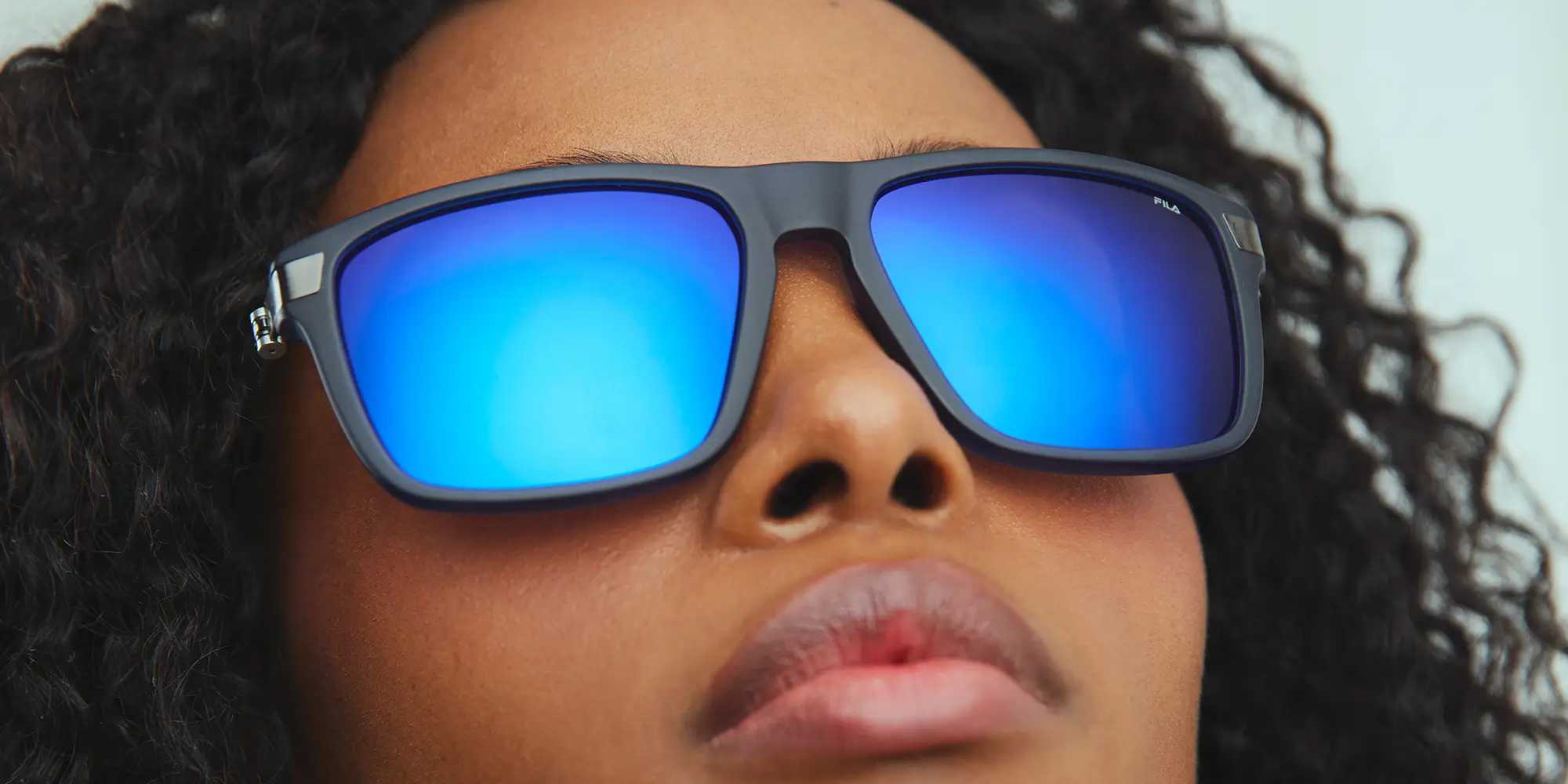 Blonde man wearing eyeglasses looks to the right with a neutral expression.