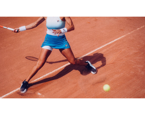 Quattro giovani posano in abbigliamento sportivo urbano su una terrazza con sfondo cittadino. Indossano capi casual come pantaloni larghi, pantaloncini, giacche sportive, top corti e sneakers. Le pose sono dinamiche e coreografiche, suggerendo un contesto di danza di gruppo o street dance. L’atmosfera è energica e moderna, con attenzione allo stile e alla coordinazione tra i membri del gruppo.